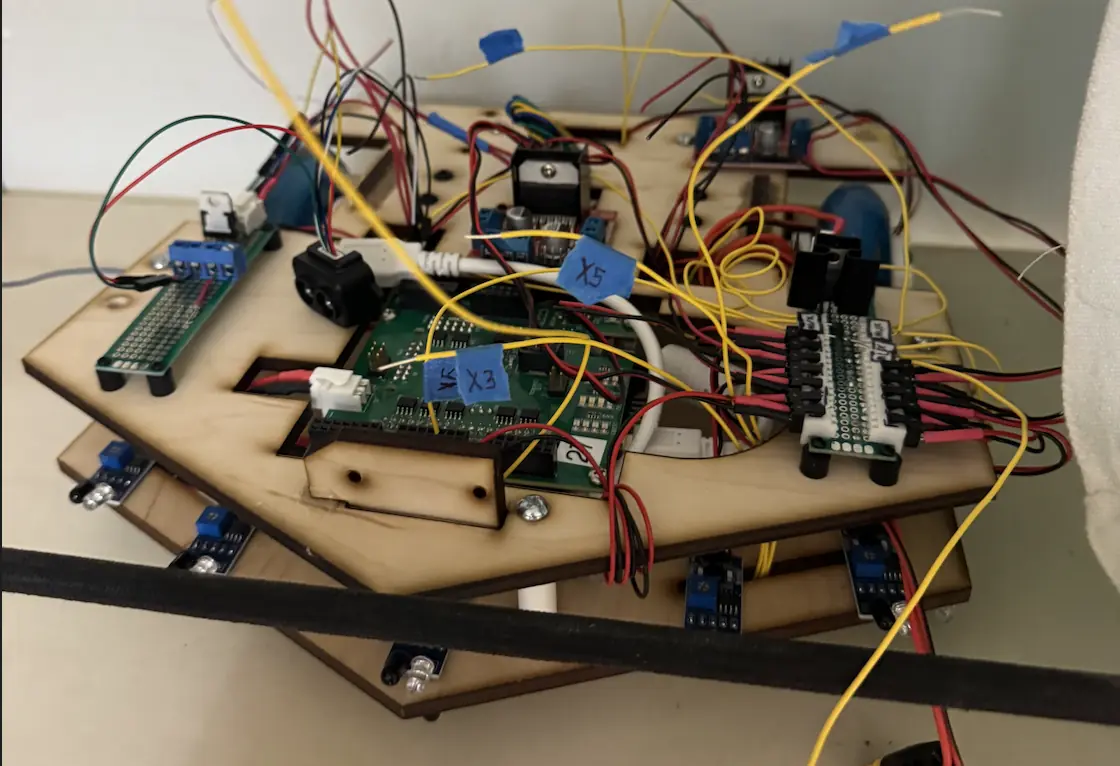 The electronics layer mid-build: Uno32 stack, motor drivers and sensor wiring on the laser-cut deck.